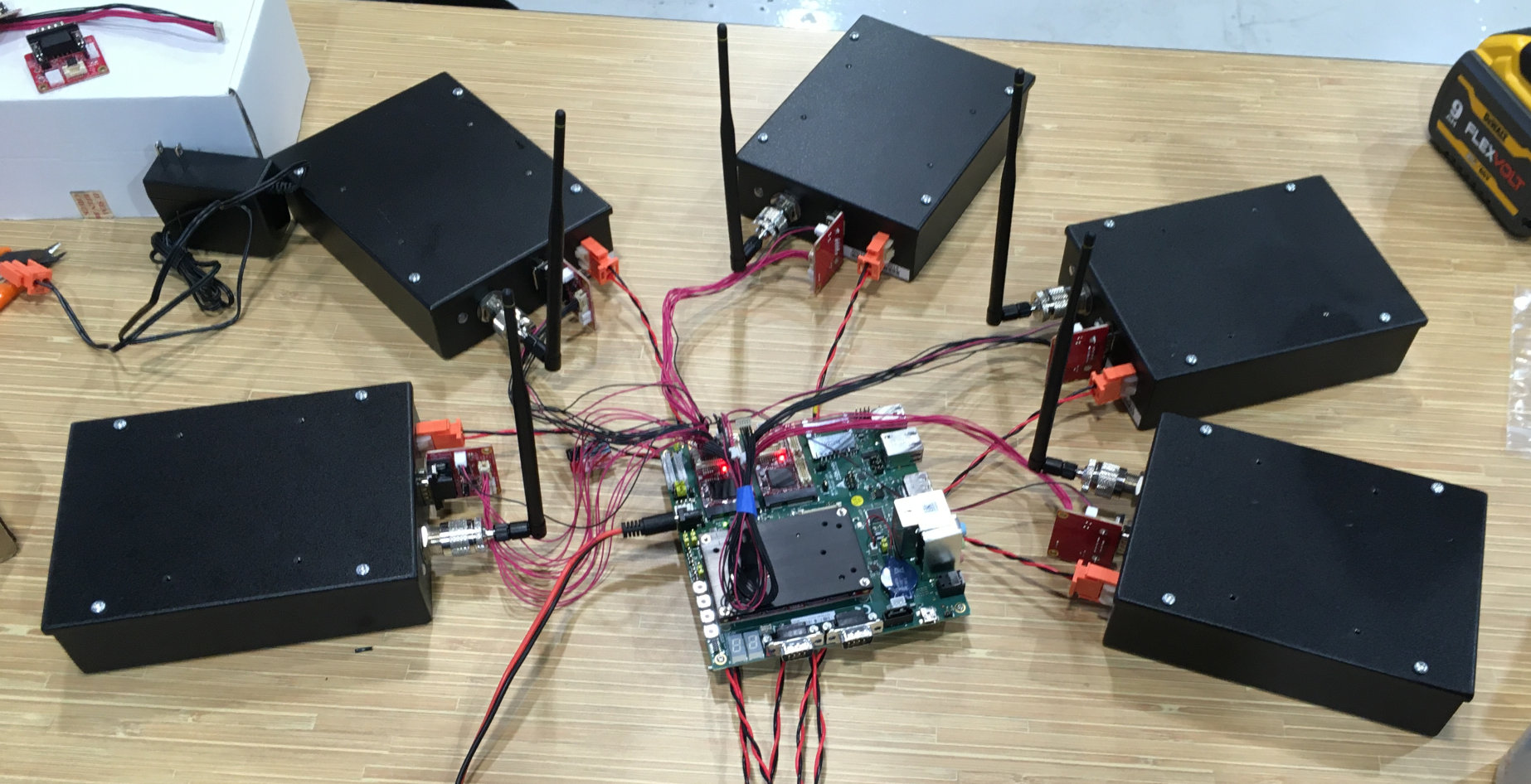 Five ICR-900 modems spread around and connected to Adlink carrier board on office table.